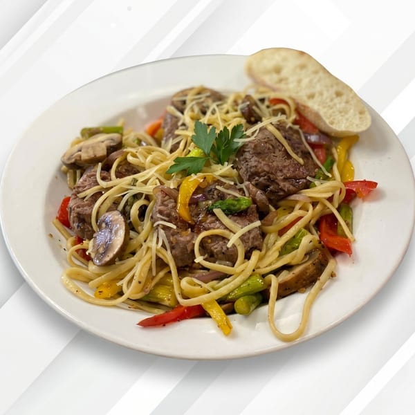 Linguine pasta with beef, colorful bell peppers, mushrooms, and a slice of bread.